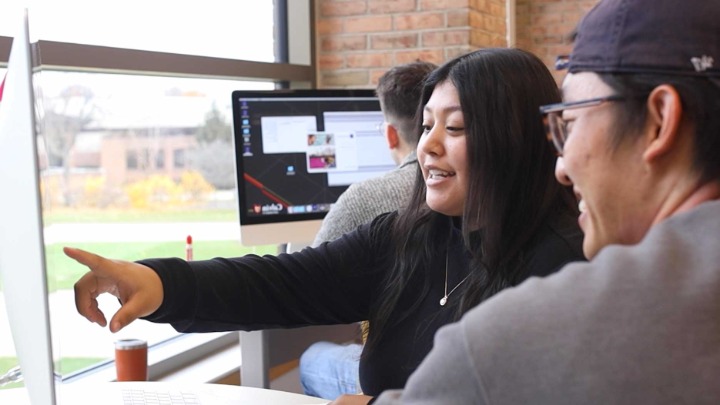 Student pointing at a screen.