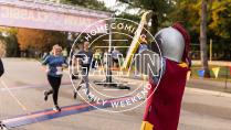 Calvin mascot Joust cheering runners across the finish line.