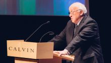 A man stands at a podium giving a lecture.