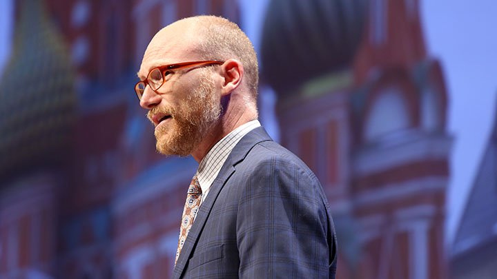 The side-view of a male faculty member giving a talk from behind a podium.