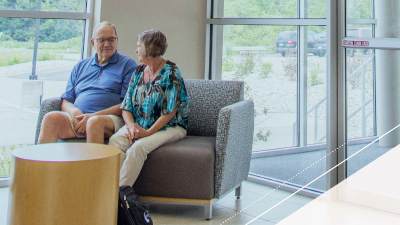 Man and woman have a conversation together on a couch.