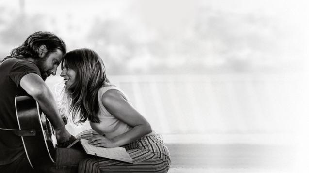 Bradley Cooper - guitar in hand - and lady Gaga stare into each other's eyes lovingly.