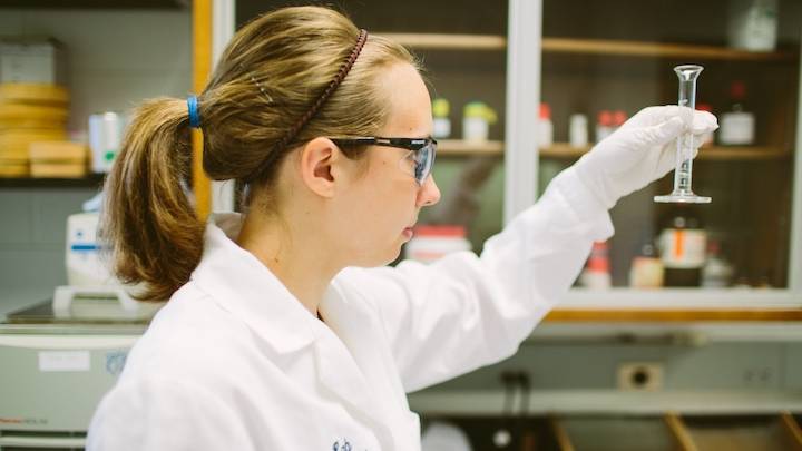 A lab assistant handling a piece of laboratory equipment