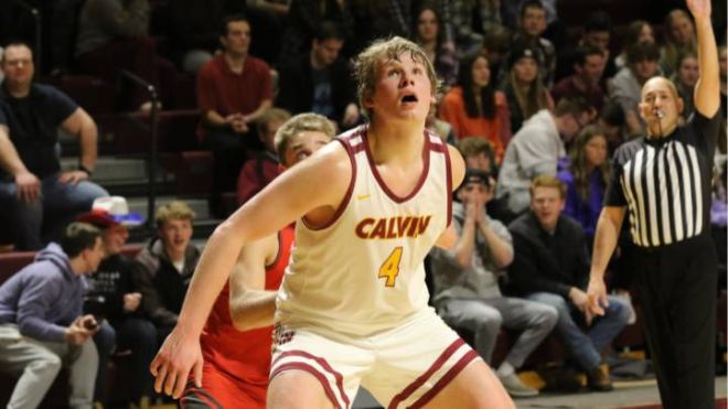 A Calvin men's basketball player boxes out a defender during a game.