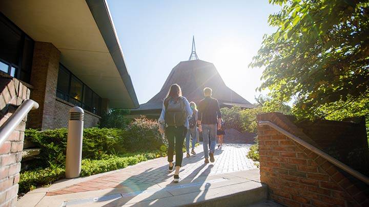 Students accend the stairs on the walkway leading past the University Chapel.