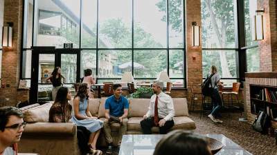 President LeRoy sitting and talking with students in Spoelhof Lobby