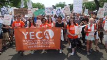 Young people carry a banner that reads 