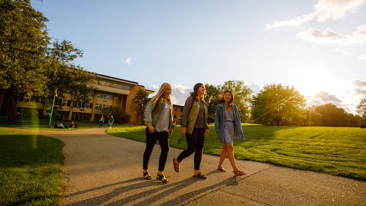 Students with laptops on the Calvin Commons Lawn