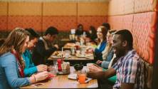 Students gathered around a table for a meal.