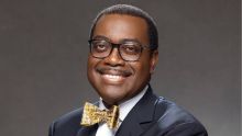 A man with glasses, bow tie, and suit coat smiles at the camera.