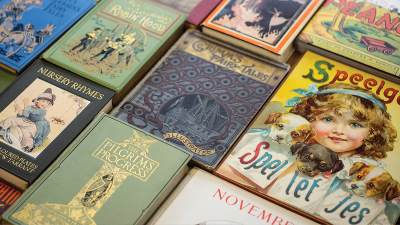 Large assortment of colorful childrens books covers lined up on a table