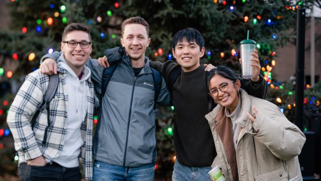 Calvin University students standing in front of the campus Christmas tree