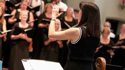 Pearl Shangkuan conducting a choir.