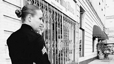 Dana Grant, in uniform, walking along city streets.