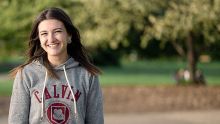 Calvin University female student smiling at the camera on campus in Grand Rapids, Michigan