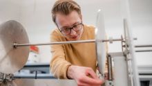 A closeup of a student working intently on his senior design engineering project.