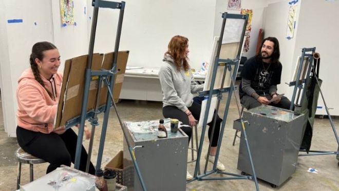 Ivan Longoria interacting with his classmates at Calvin University in an art studio.