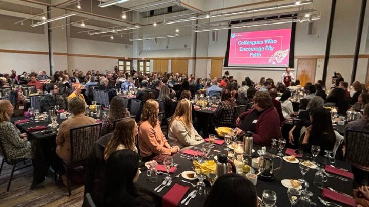 A few hundred people gathered at dozens of tables enjoy a Thanksgiving luncheon.