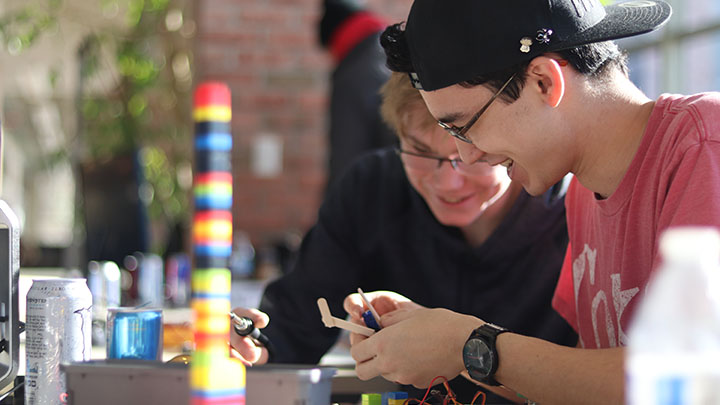 Two students working intently on a software/hardware development project.