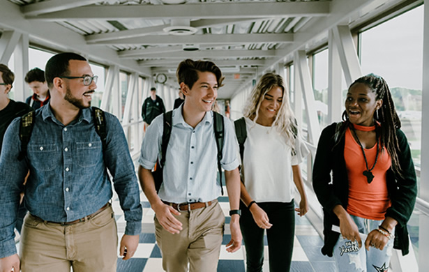 Calvin University students walking across the Calvin Crossing bridge over the East Beltline